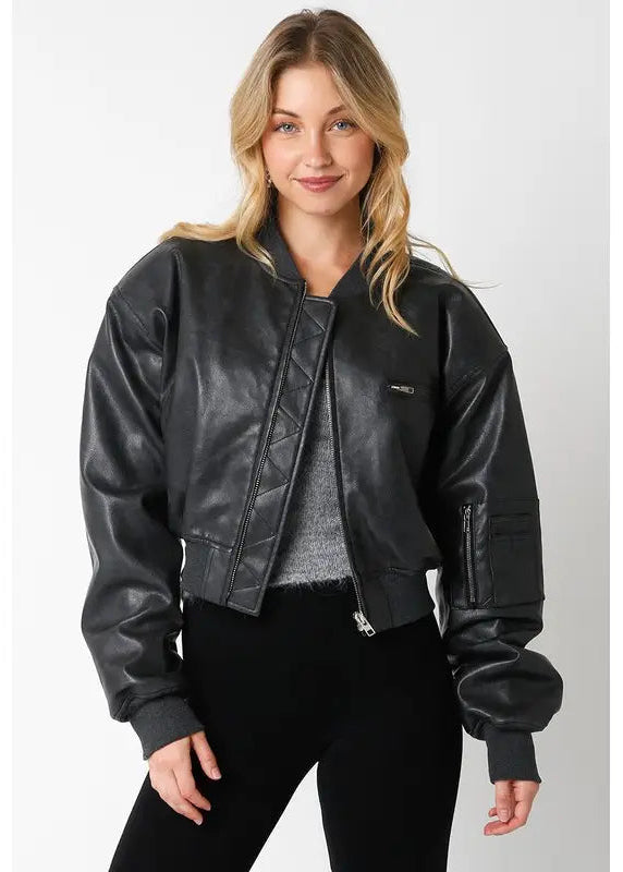 Woman wearing a black leather bomber jacket on a white background