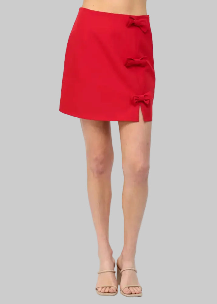 Red skirt with bow details worn by a person on a white background
