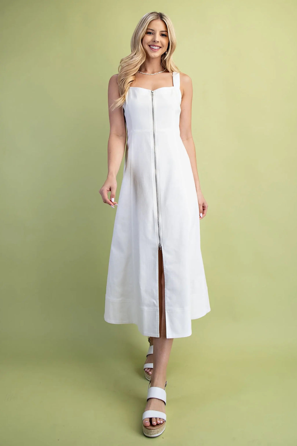 Woman wearing a white dress on a green background