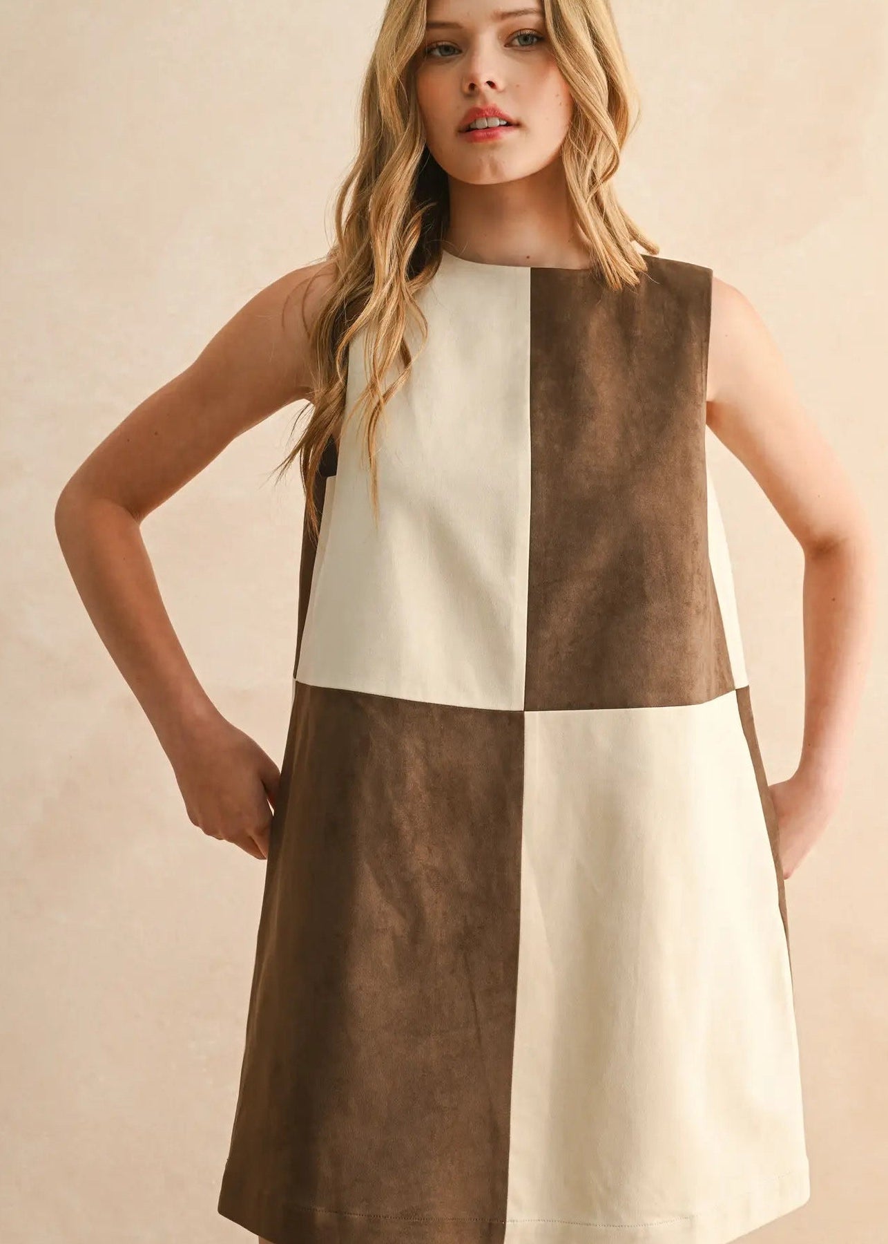 Woman wearing a two-tone dress with brown and white colors on a beige background